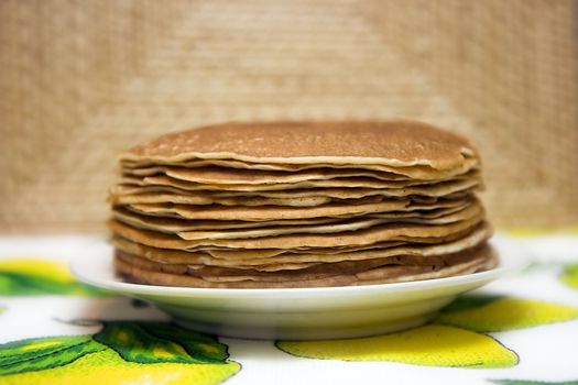 Pancakes on a plate on a bright cloth