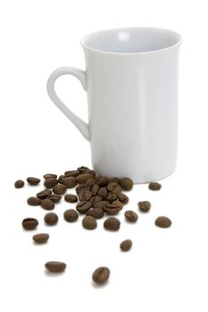 Cup and scattered grains of coffee on a white background