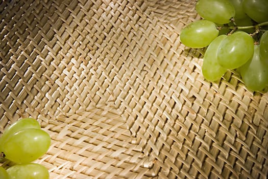 Background from rods with green grapes along the edges