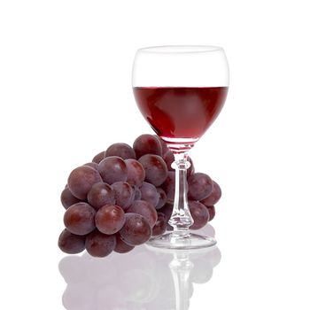 Red grapes and glass with wine on a white background