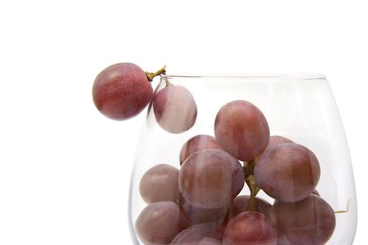 Grapes in the big wine glass on a white background