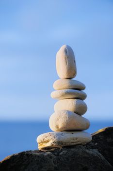 Balancing of white pebbles on the sea coast