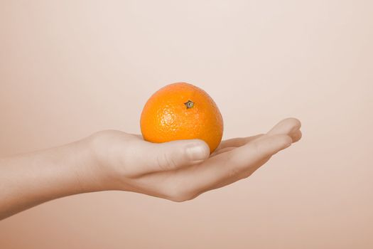 On a children's palm the orange tangerine lies