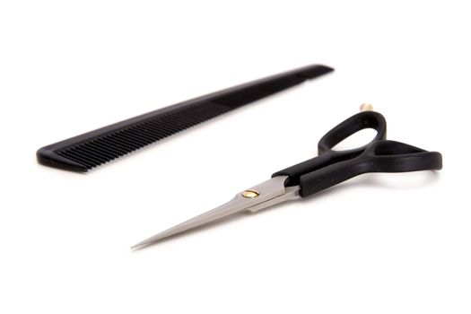 Hairdresser's scissors and hairbrush on a white background
