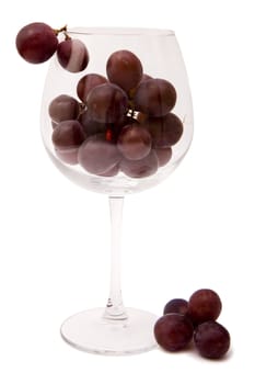 Red grapes in a glass on a white background