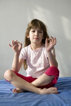 Young woman doing yoga moves or meditating. You can use top part as copyspace.