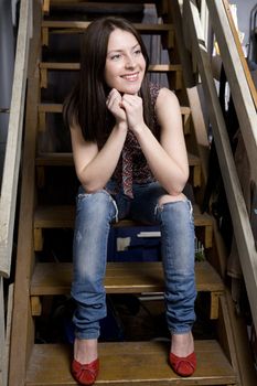 young attractive smiling  girl sitting on stairs