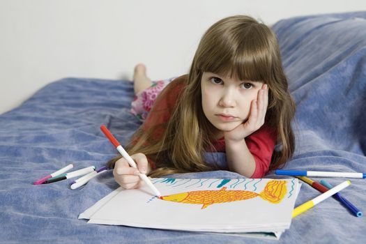 little cute serious girl seven years old with drawing picture