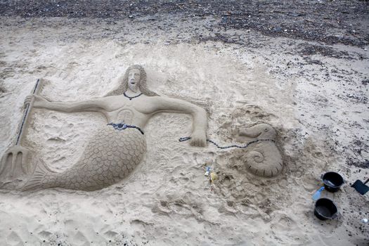 Thames. Neptune. Man build sculpture from sand
