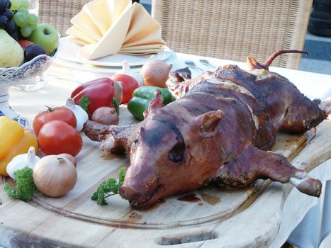 broiled piglet with vegetables on fresh air. Dinner in garden