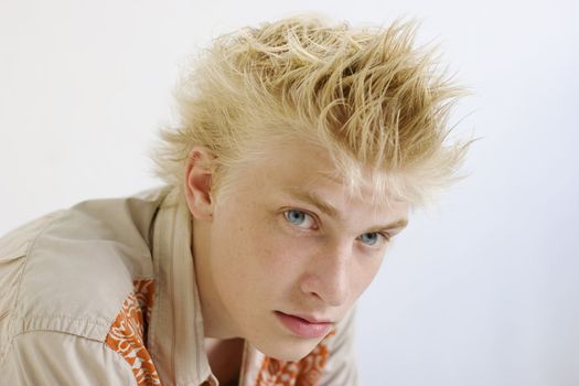 close up portrait young blond serious man with blue eyes