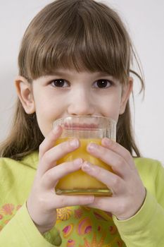 little cute adorable girl seven years old drink orange juice