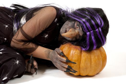 girl dressed up as a witch sleeping on a pumpkin