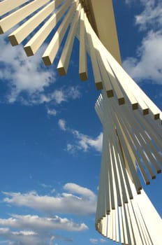 Blue skies littered with white clouds backdrops a beautiful collage of white hanging  things.