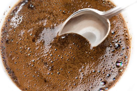 Teaspoon in a thick foam of ground coffee 