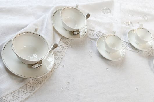Four teacups on a table with tablecloth