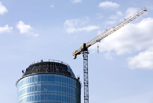 Climber constructor work on blue glass skyscraper 