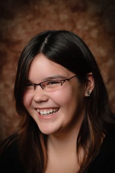 A young preteen girl laughing when she's getting her portrait done