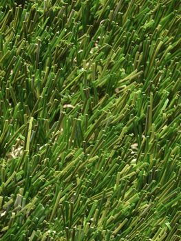 Detail of green grass artificial lawn meadow, useful as a background