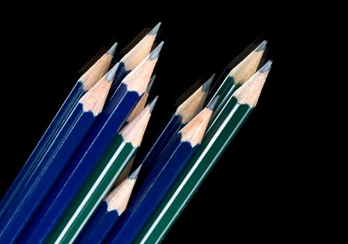 Kit of green and blue pencils on black background