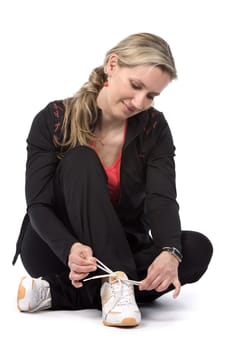 Young women with sportswear sitt on the floor. White background