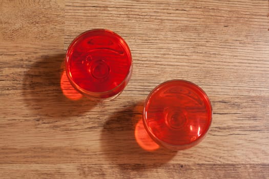 Two glasses with jelly stand on wooden, oak floor