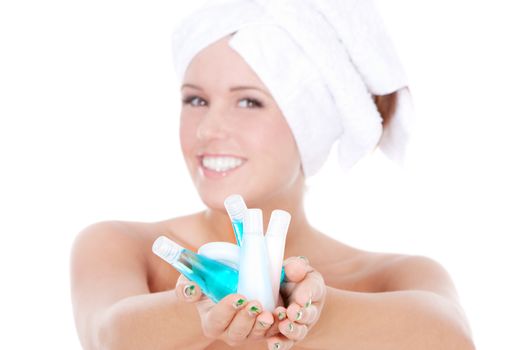 Spa woman holding bottles with shampoo. Focus on hands.