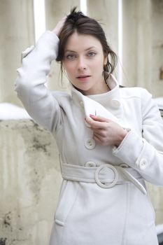 young attractive serious woman wearing white overcoat