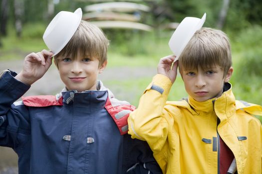 happy cute twins brothers eight years old pretend to have cap - plastic  plate