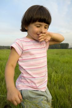 little cute pensive girl five years old standing on the park 