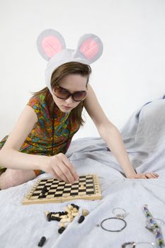 portrait young attractive woman wearing funny  mouse cap playing chess