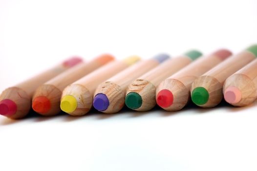 colored wooden pencils closeup over white backgroud