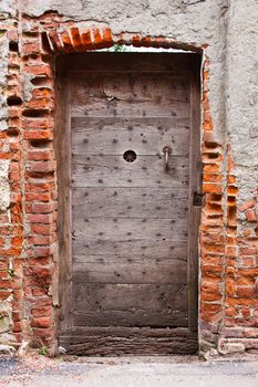 Old door made of wood, abandoned building entrance, Italy