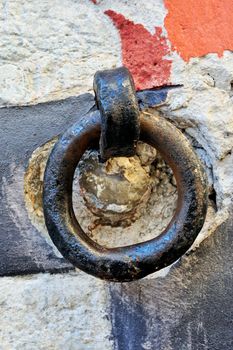 Metal hoop with rust on the stone wall