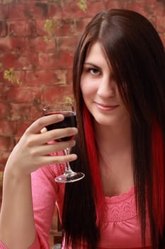 closeup on cute caucasian girl holding a red wine glass