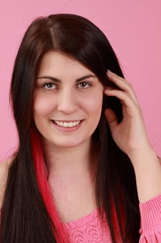 cute caucasian girl with hand on her hair,  pink background