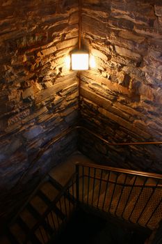 A dimly lit stairwell curls into the darkness.