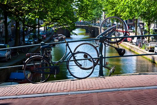 Tipical bicycles parking in Amsterdam, in front of a tipica canal
