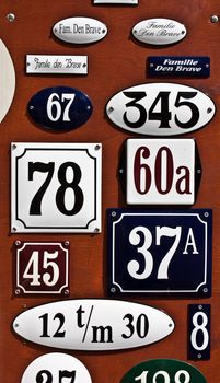 Collection of metallic plates with numbers and surnames