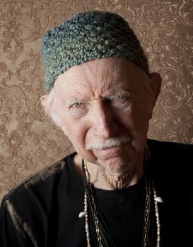 Senior tough guy in green knit cap leaning