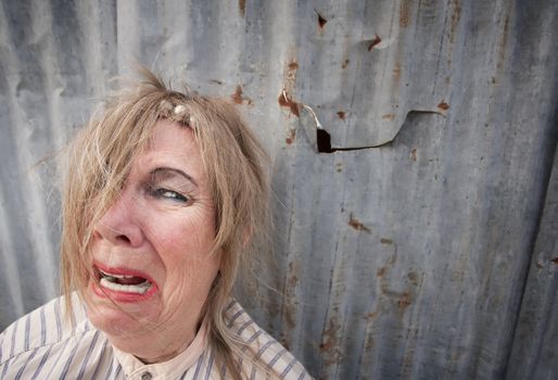 Senior homeless woman with too much makeup crying