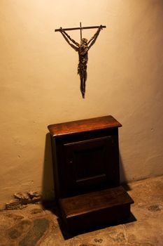 Old crucifix with faldstool in a catholic abbey