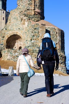 A family is walking for exercise close to an old monastery
