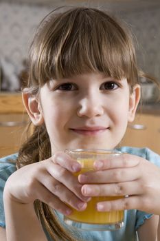 little cute smiling girl seven years old drink orange juice