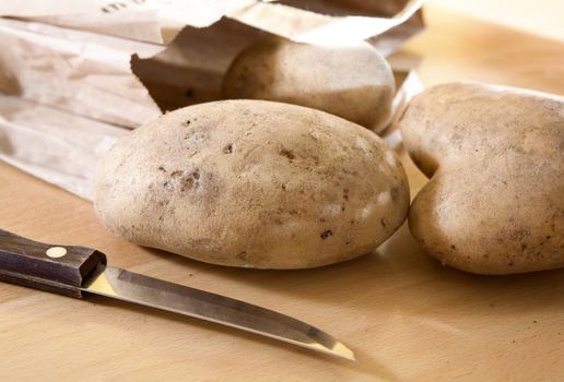 potato in parcel  and knife on the table