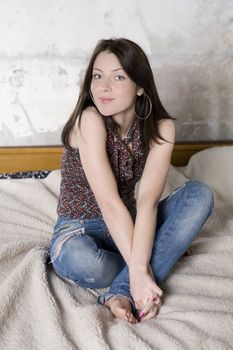 young attractive pensive woman in jeans and bare food