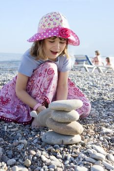 Little cute girl six years old  in panama building piramid on beach