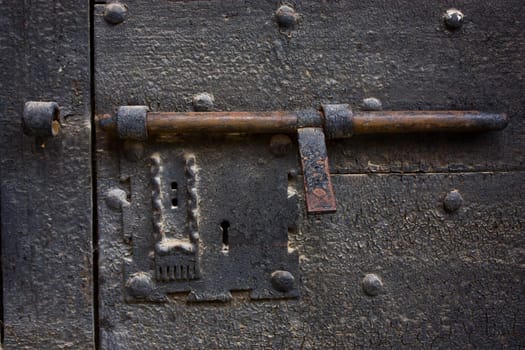 Ancient lock made of metal on a medieval door