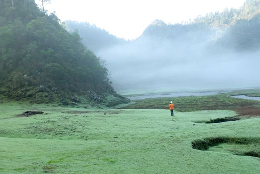 There was a womnan walk on the mist grassland.