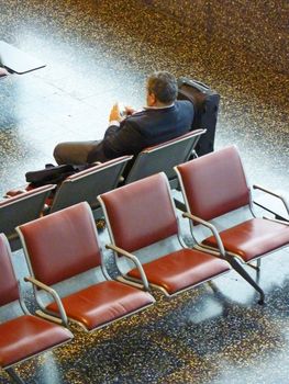 Businessmen that is wainting alone his flight working with his pocket pc